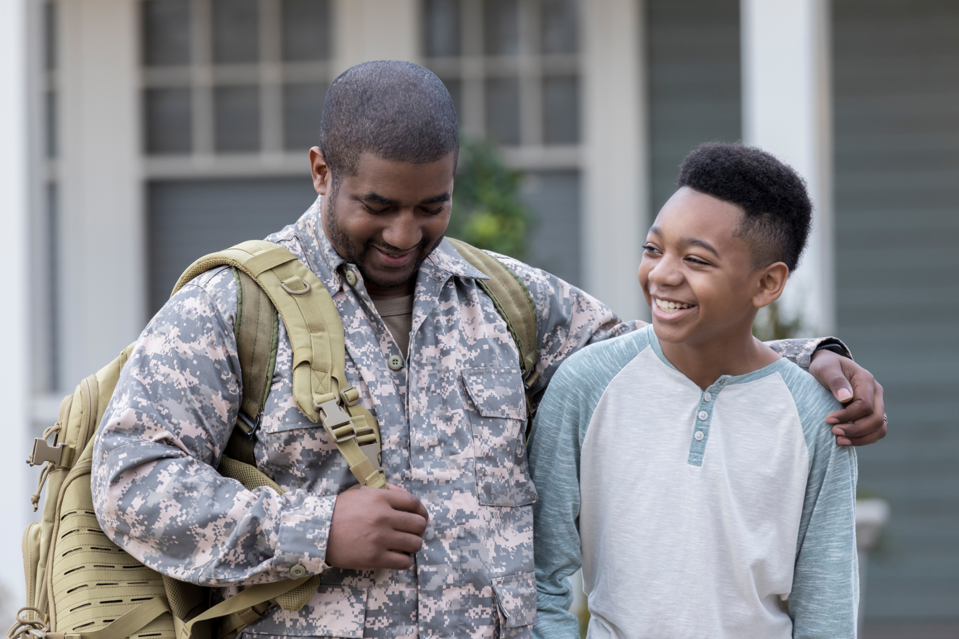 Military parent and middle school student walking together arm in arm.