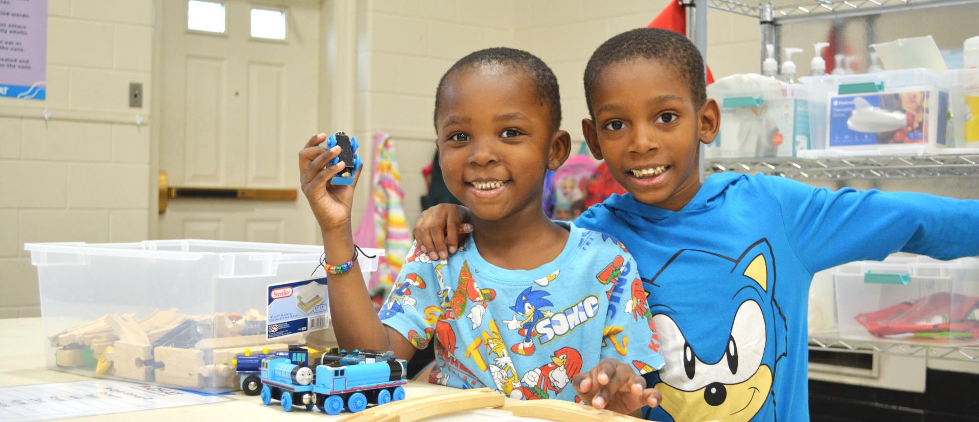 Two boys playing with trains at the Neighborhood Resource Center