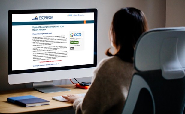 Image of a parent reading about Learning Acceleration Grants on the computer